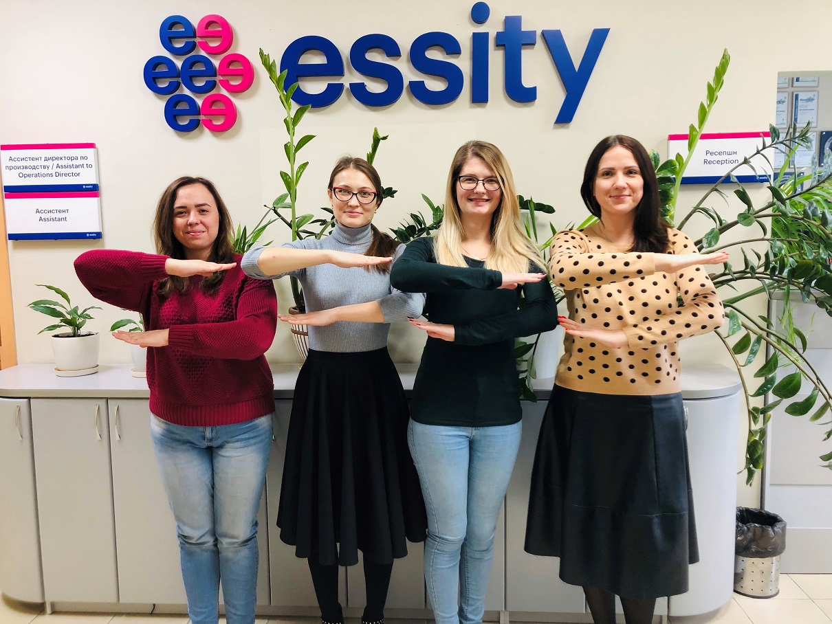Women hold up equal signs in front of an Essity logo