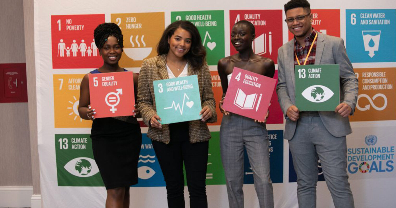 SouKenya Diaouf and others pose with signs promoting the Sustainable Development Goals